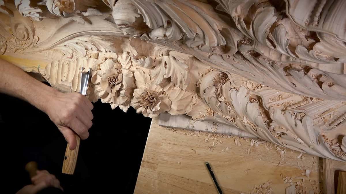 Carving in progress on a small practice board with a gouge and mallet