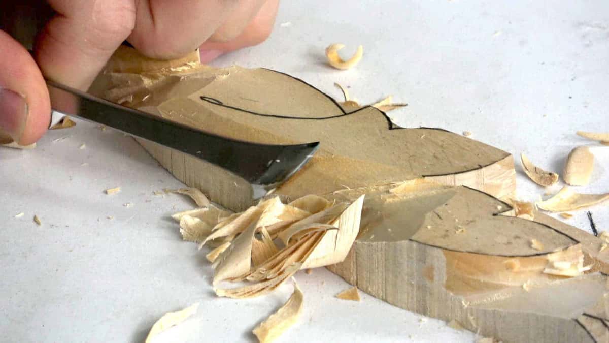 Wide chisel slicing an acanthus lobe, thick shavings curling off