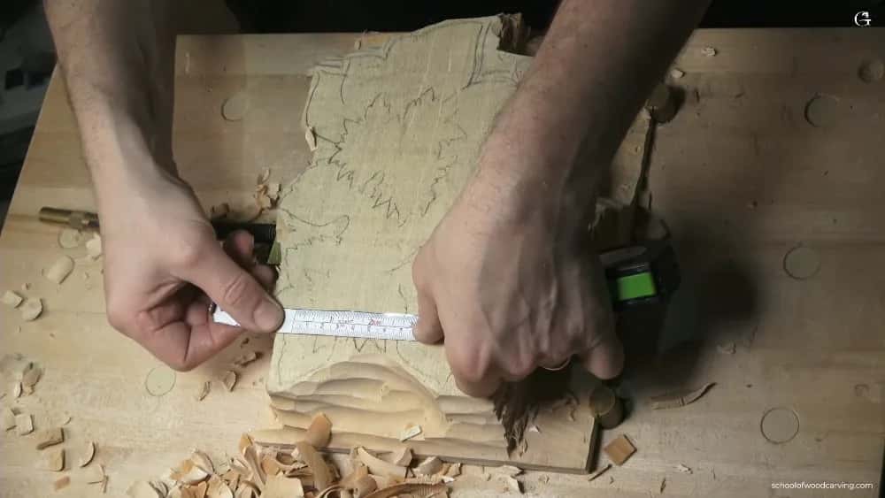 A steel rule and pencil marking a roughed panel, the paper pattern still glued down