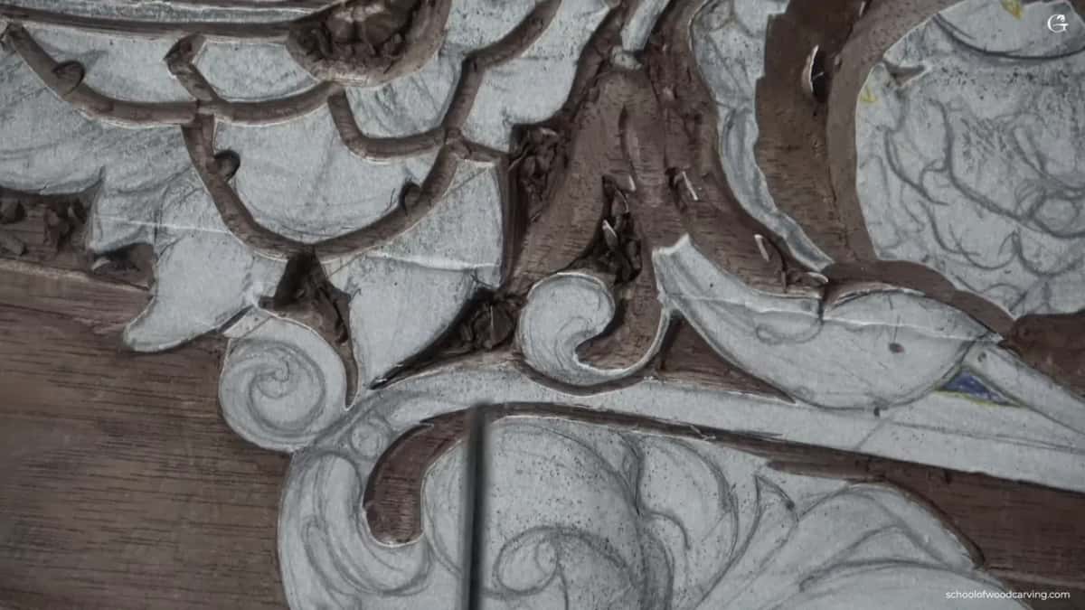 Layered acanthus leaves in relief on dark reddish wood, deep shadow falling between the layers.