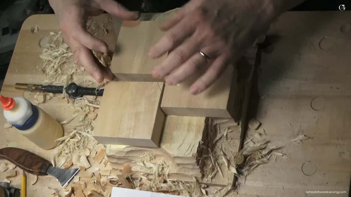 Both hands press two square blocks together so the fresh joint line between them almost disappears.
