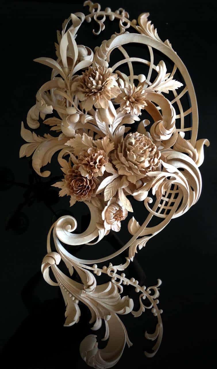 Pierced and undercut: chrysanthemums, a lattice and a ribbon of acanthus, shot against black so the shadows show