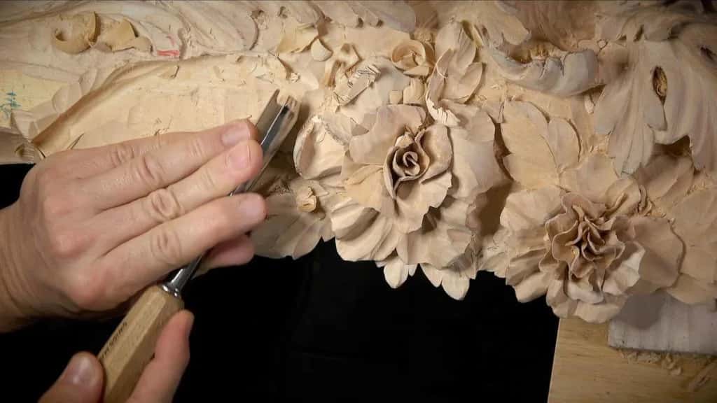 Carved roses on the Venice room panel, a gouge working between two of them and chips everywhere