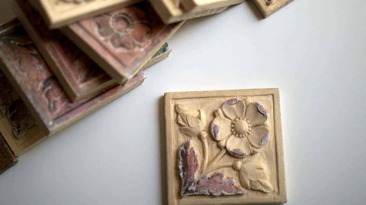 Flower rosette carved in basswood beside a painted antique panel