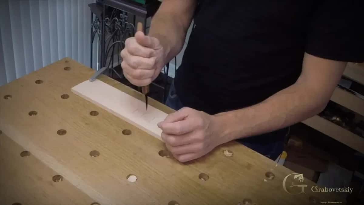 A vertical stop with a carving knife Both fists wrapped round the handle while the blade goes straight down into the end of a basswood strip